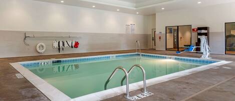 A swimming pool with a tiled edge, a ladder, and a water fountain.