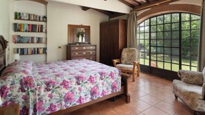 A bedroom with a bed, a chair, a dresser, and a bookshelf. - Bouganville by Interhome (Bibbona)