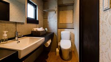Un baño con lavamanos, inodoro y ventana.