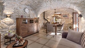 A rustic stone interior with a dining area, wooden cabinets, and a cozy seating arrangement. - Beautiful home in Tribalj (Tribalj)