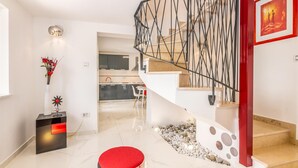 Ein modernes Interieur mit Treppe, Küchenbereich und Essplatz.