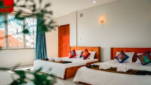 A hotel room with two beds, a wooden headboard, and a window with decorative iron bars. - Intanou Boutique Hotel Kampot (Kampot)