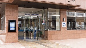 A building entrance with a glass door, a digital information board, and a sign indicating a medical facility. - Toyoko Inn Joetsumyoko-eki Nishi-guchi (Joetsu)
