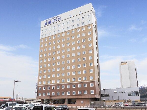 A multi-story hotel with a prominent sign for Toyako Inn. - Toyoko Inn Joetsumyoko-eki Nishi-guchi (Joetsu)