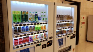 Two vending machines stocked with beverages and snacks, including Coca-Cola and Fanta, in a well-lit indoor setting. - Toyoko Inn Joetsumyoko-eki Nishi-guchi (Joetsu)