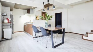 A modern kitchen with a central island, grey chairs, and pendant lighting. - FC House Shibuya No.1 (Tokyo)