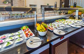 A buffet with various food items, including fruits, salads, and appetizers.