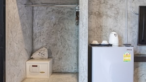 Une chambre d’hôtel avec un mur en marbre, un sèche-cheveux, un four à micro-ondes et une bouilloire sur le comptoir.