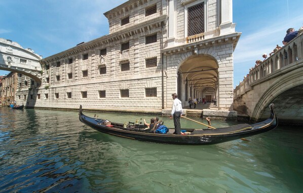 Una góndola en un canal con un edificio histórico al fondo.