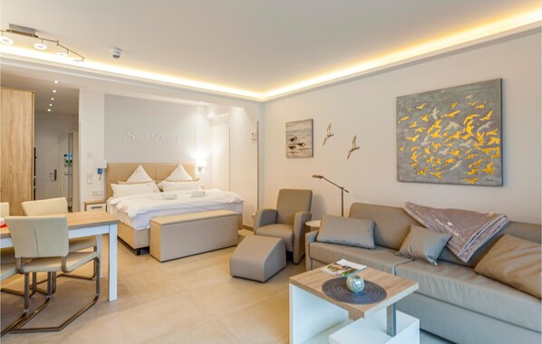A modern hotel room with a bed, a sofa, a coffee table, and a desk. - Prora Solitaire Panorama 03 (Binz)
