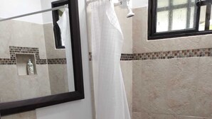 A bathroom with a toilet, sink, and shower area. - Finca Campestre J&J (Quimbaya)