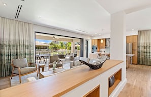 A modern living area with a wooden coffee table, seating, and a view of the outdoors.
