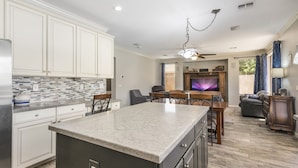 A modern kitchen with white cabinets, a granite countertop, and a built-in island. - Amazing pool, arcade game and basktball game loft, pool table, 5 bedrooms (Gilbert)