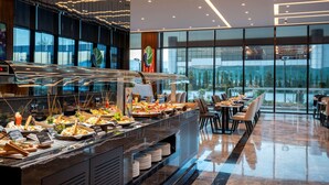A buffet with various food items and a seating area with tables and chairs. - Radisson Blu Hotel, Sakarya (Arifiye)