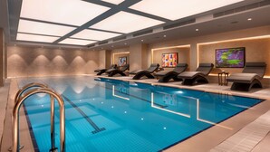A modern indoor swimming pool with lounge chairs and a ceiling with skylights. - Radisson Blu Hotel, Sakarya (Arifiye)