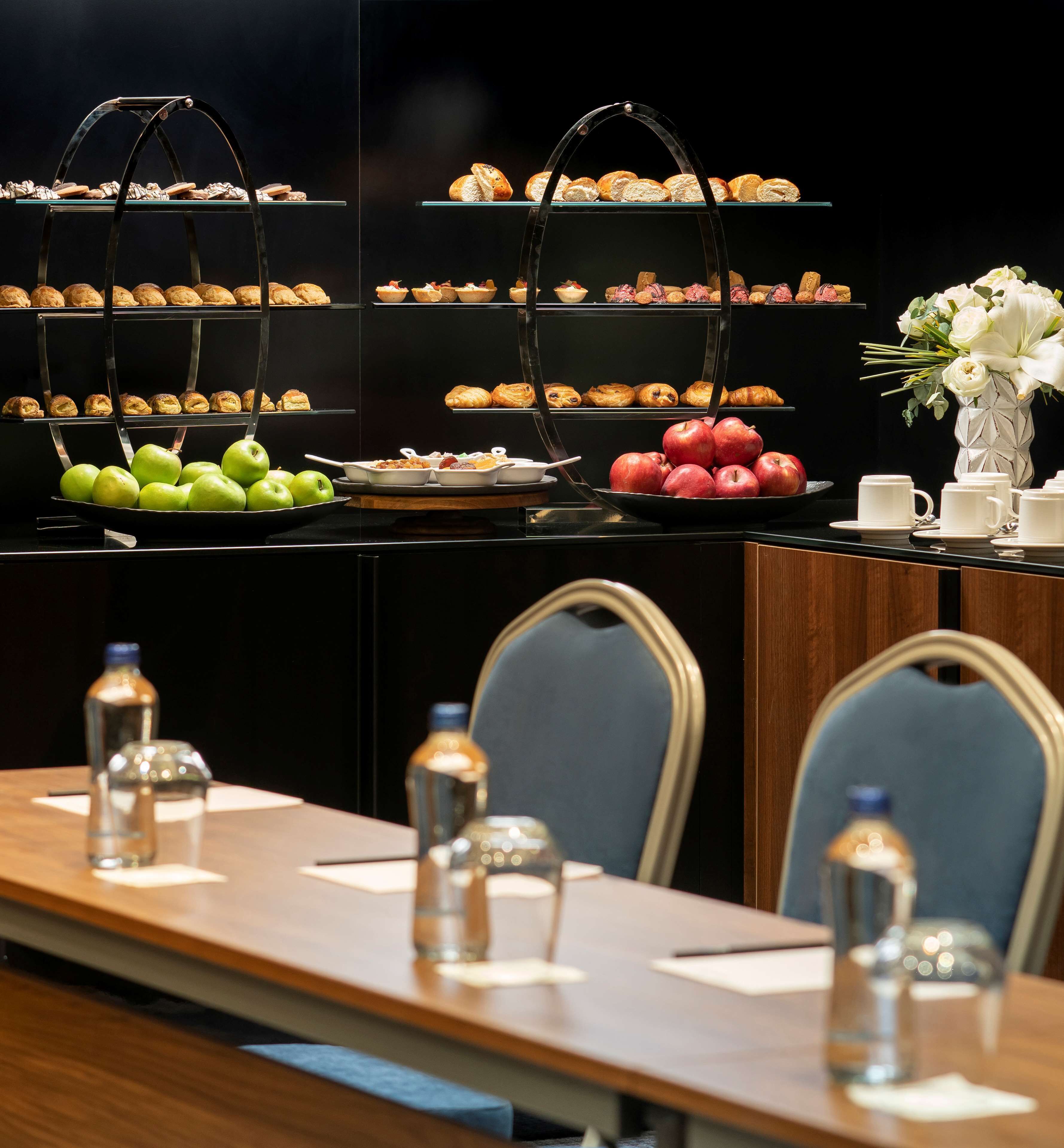 A buffet setup with various pastries, fruits, and beverages.