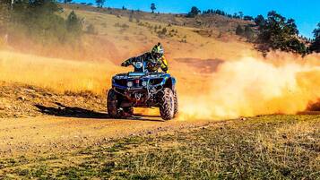 A person riding a quad bike on a dirt path.