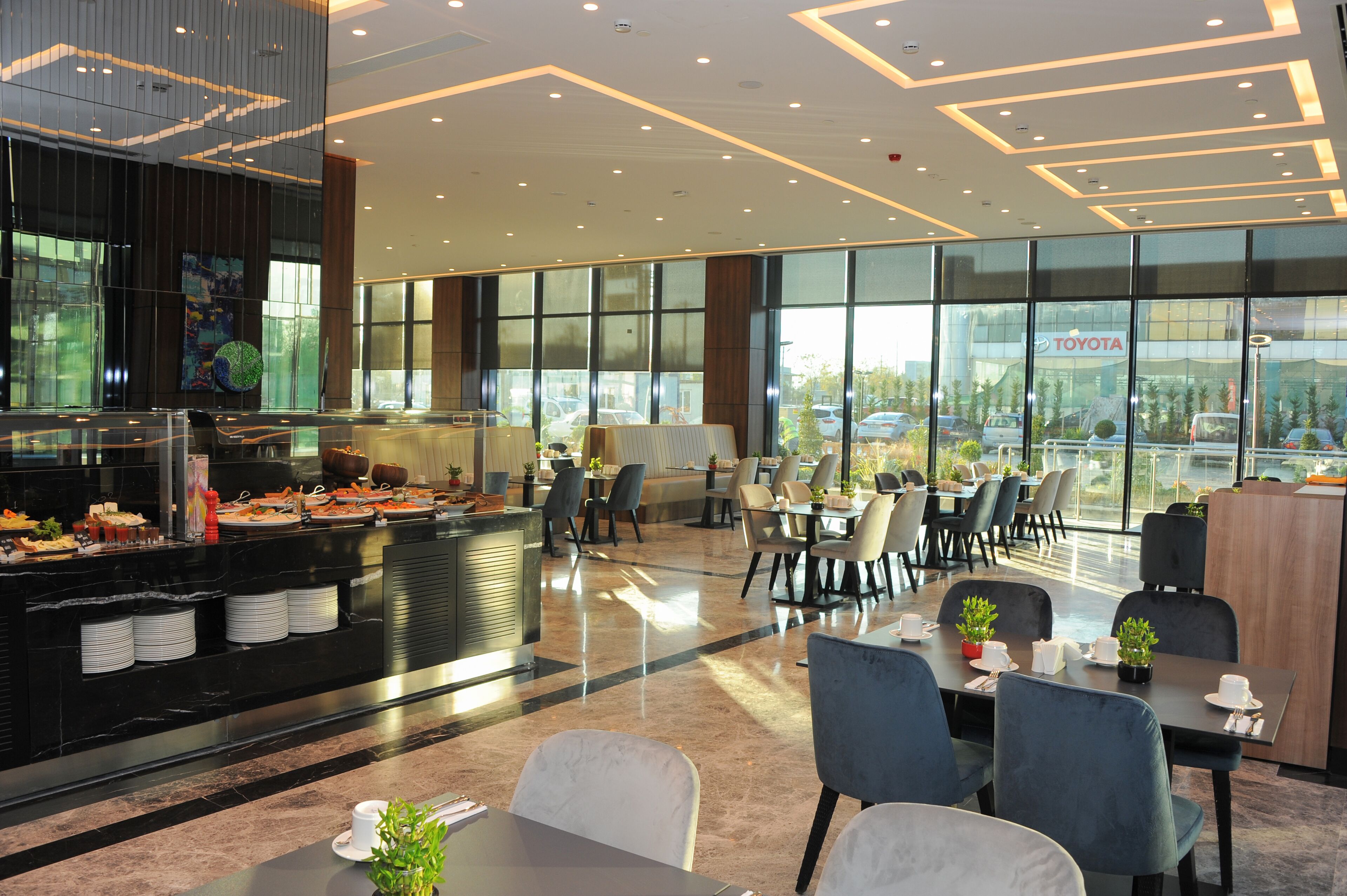 A modern restaurant with a buffet, dining tables, and chairs.