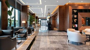 A modern lobby with leather seating, a reception desk, and a large window. - Radisson Blu Hotel, Sakarya (Arifiye)