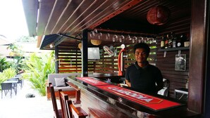 Un espace bar avec un comptoir, des sièges et une vue sur l’extérieur.