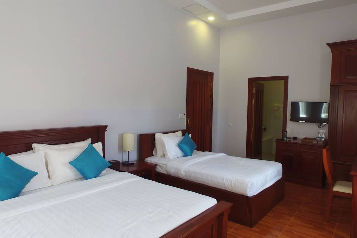 A hotel room with two beds, a desk, a television, and a wardrobe.