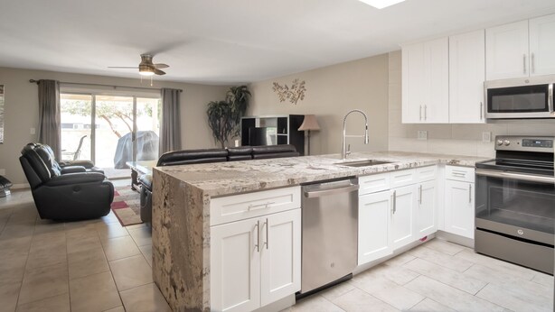 A modern kitchen with white cabinets, a built-in dishwasher, and stainless steel appliances. - Beautiful CLEAN Townhome in East Mesa -  w/Community Heated Pool (Mesa)