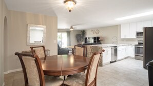 A modern kitchen with white cabinets, a dining table with chairs, and a ceiling light fixture. - Beautiful CLEAN Townhome in East Mesa -  w/Community Heated Pool (Mesa)