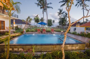 Una piscina al aire libre, sombrillas, sillones reclinables de piscina