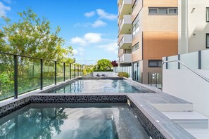Una piscina al aire libre, sillones reclinables de piscina