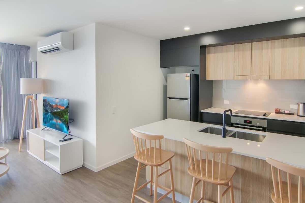 A modern kitchen with a white countertop, wooden cabinets, and a built-in oven.