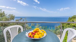 A table with a fruit bowl on a balcony overlooking the sea. - Nice apartment in Stara Baska with WiFi (Stara Baska)