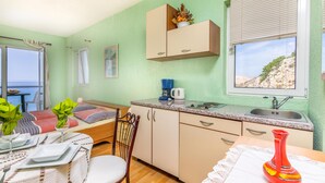 A compact kitchen with a dining area, a view of the sea, and a window with a scenic view. - Nice apartment in Stara Baska with WiFi (Stara Baska)