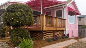 A pink house with a wooden deck and a covered porch. - Perfect Pink Paradise (Cayucos)