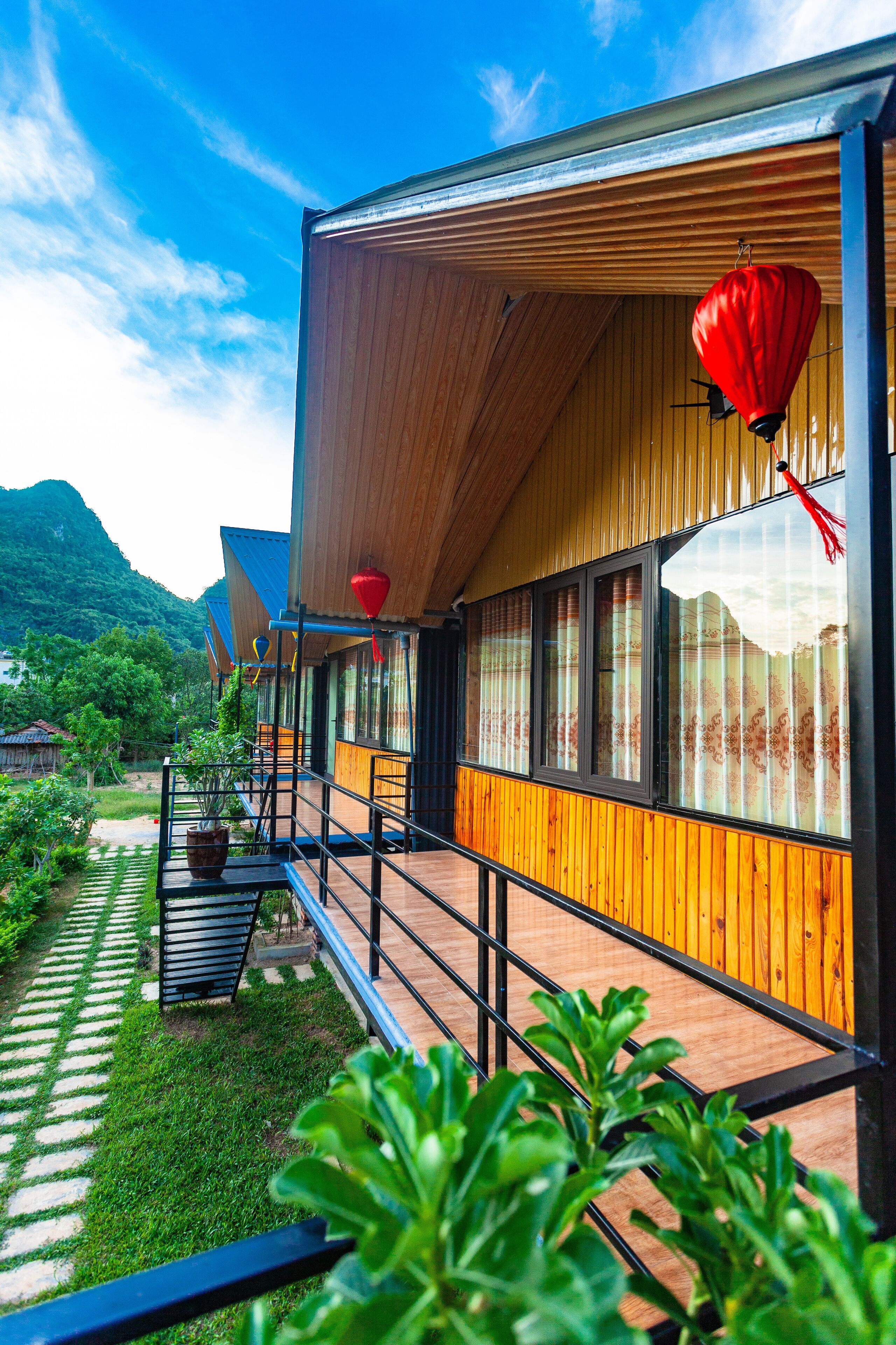 A modern building with wooden exterior walls, large windows, and a balcony with a railing.