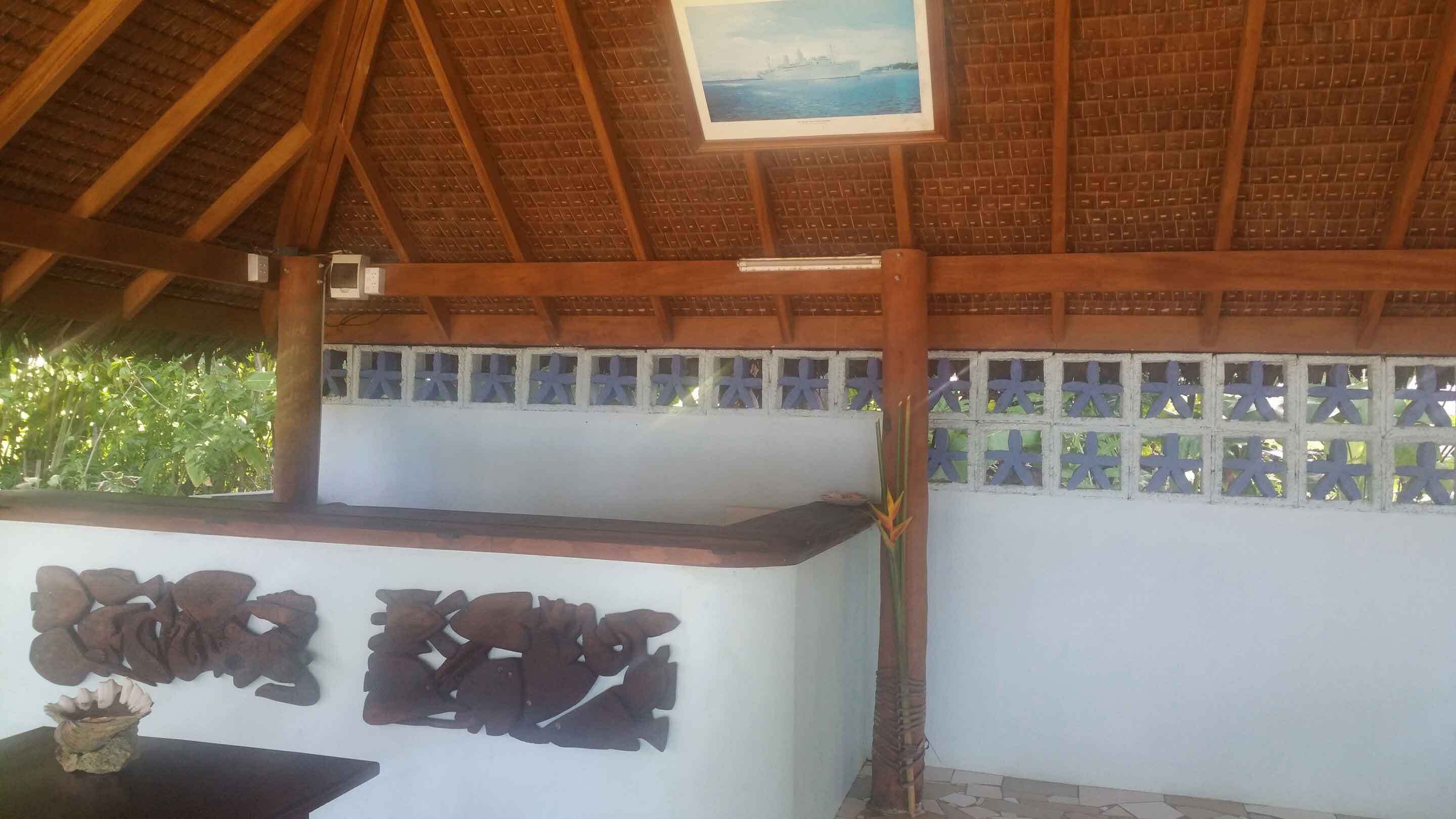 Un bâtiment doté d’un toit en bois et d’un mur blanc sur lequel est apposée une enseigne.