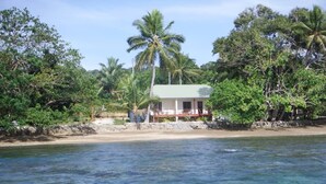 A beachfront property with a house, palm trees, and clear water. - Santo Seaside Villas (Luganville)