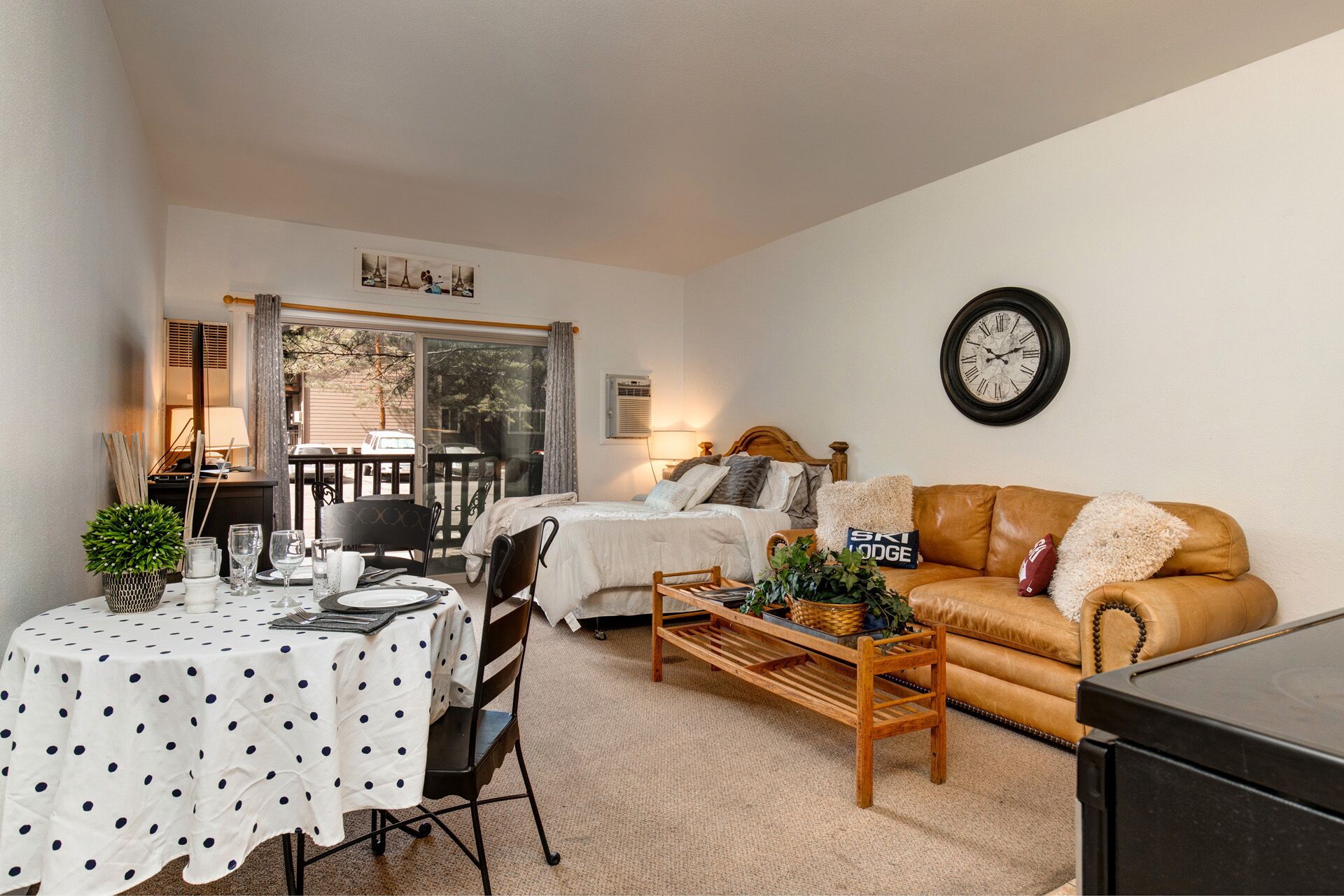 A cozy living room with a sofa, a coffee table, and a dining table set for two.