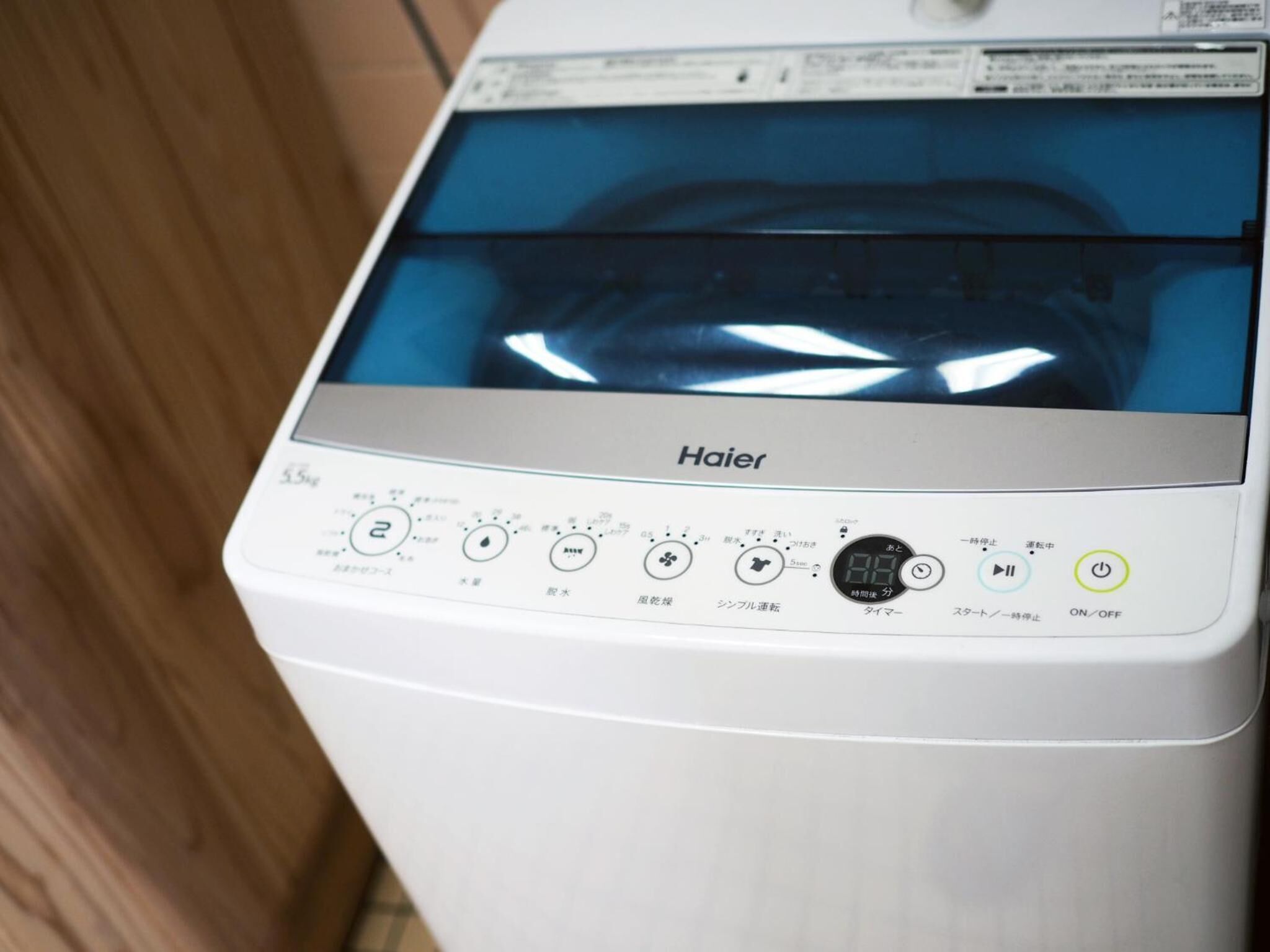 A Haier washing machine with a digital display and multiple control buttons.