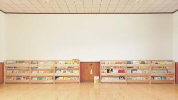 A room with wooden bookshelves filled with books, a wooden door, and a tiled ceiling.