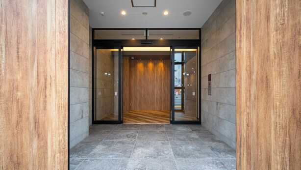 A modern elevator with a wooden interior and a glass door, leading to a hallway with grey tiled flooring. - Hotel Classe Stay Sapporo (Sapporo)