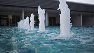 Una piscina al aire libre, sillones reclinables de piscina