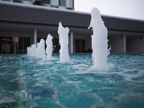 Une piscine dotée de plusieurs jets d’eau, située dans un bâtiment moderne.