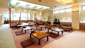 A spacious room with multiple wooden tables and benches, large windows, and a ceiling with recessed lighting. - Sauna Capsule Hotel Core 21 - Caters to Men (Tokyo)