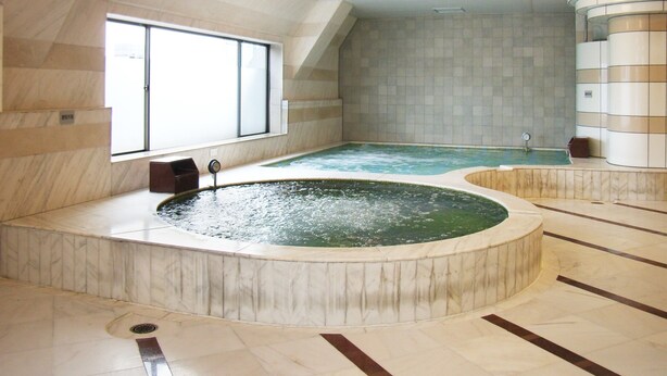 A spa area with two hot tubs, a large window, and a tiled floor. - Sauna Capsule Hotel Core 21 - Caters to Men (Tokyo)