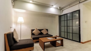 A modern living room with a sofa, a coffee table, and a floor lamp. - StayAt Bedever Bangkok Hotel (Bangkok)