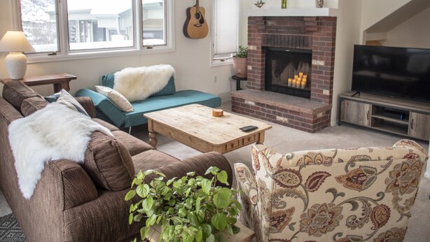A living room with a sofa, a coffee table, a fireplace, a television, and a guitar. - ☞Sunny & Spacious 2 King 2 Queen in the heart of the Vail❅Valley⛷ (Avon)