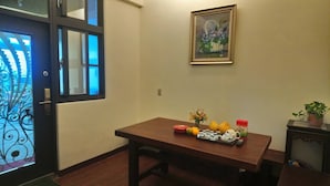 A room with a wooden table, a framed painting, and various items on the table including fruits, a vase, and a small plant. - Flower Bed&Breakfast is now Ikegami (Chishang)