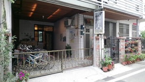 A storefront with a signboard, metal gate, and potted plants. - Flower Bed&Breakfast is now Ikegami (Chishang)