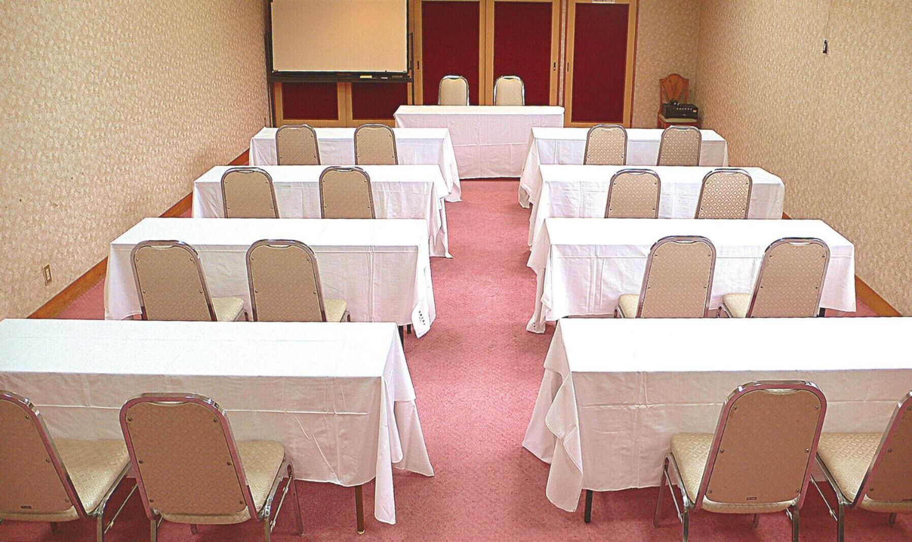 A conference room with tables and chairs arranged for meetings.