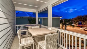 A covered porch with wicker furniture and a view of neighboring houses. - SEA YOU SOON: Gorgeous Home in Gated Neighborhood w/ Private Pool & Easy Beach Access! (Miramar Beach)